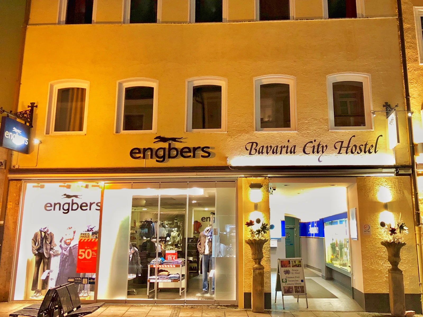 Die beleuchtete Hausfassade mit dem Schriftzug Bavaria City Hostel über dem Eingang