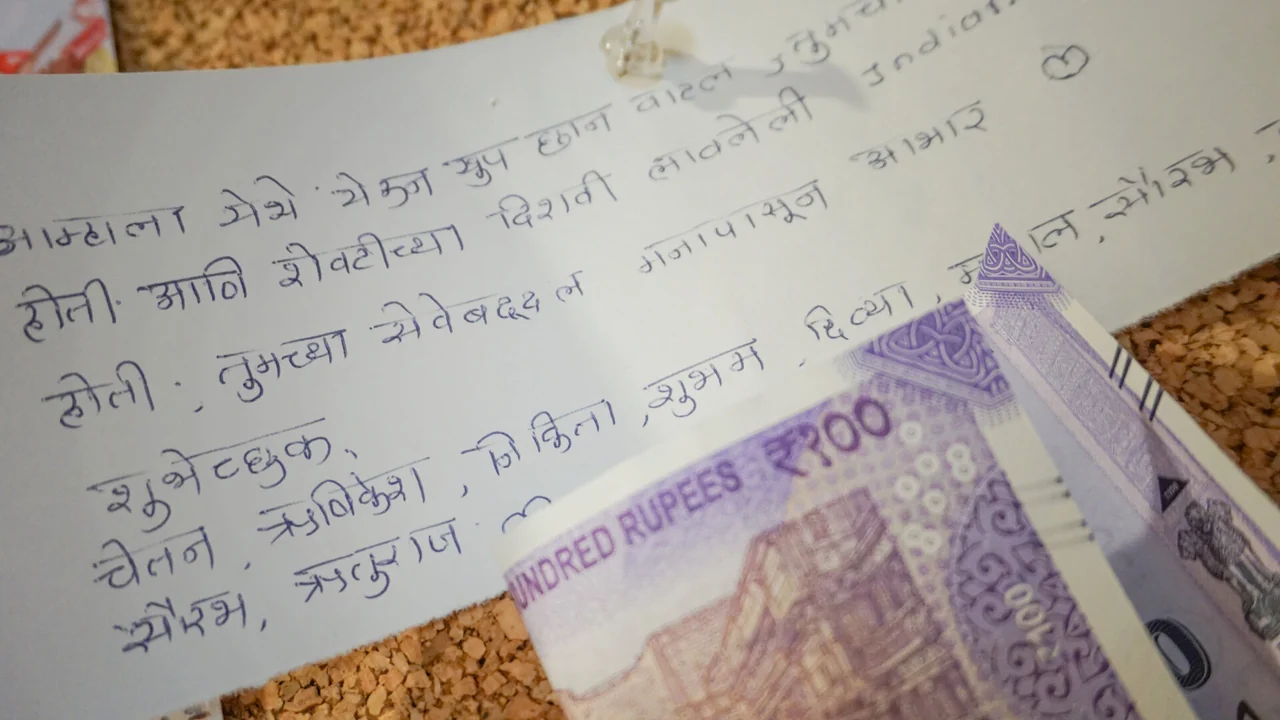 Handgeschriebene Grüße eines Gastes aus Indien und ein indischer Geldschein