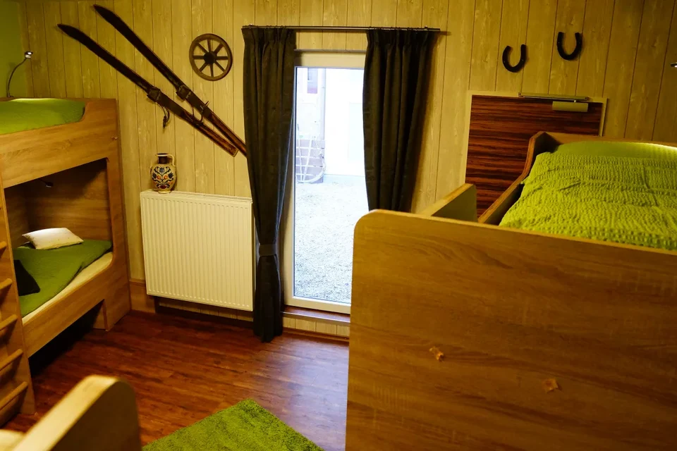 Hüttenzauber – Geselliges Zimmer für acht mit direktem Terrassenzugang.